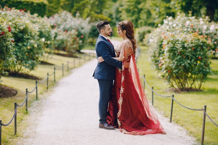 Couple posing in a beautiful garden setting, symbolizing luxury celebrations at the best resorts in Jim Corbett for destination weddings.